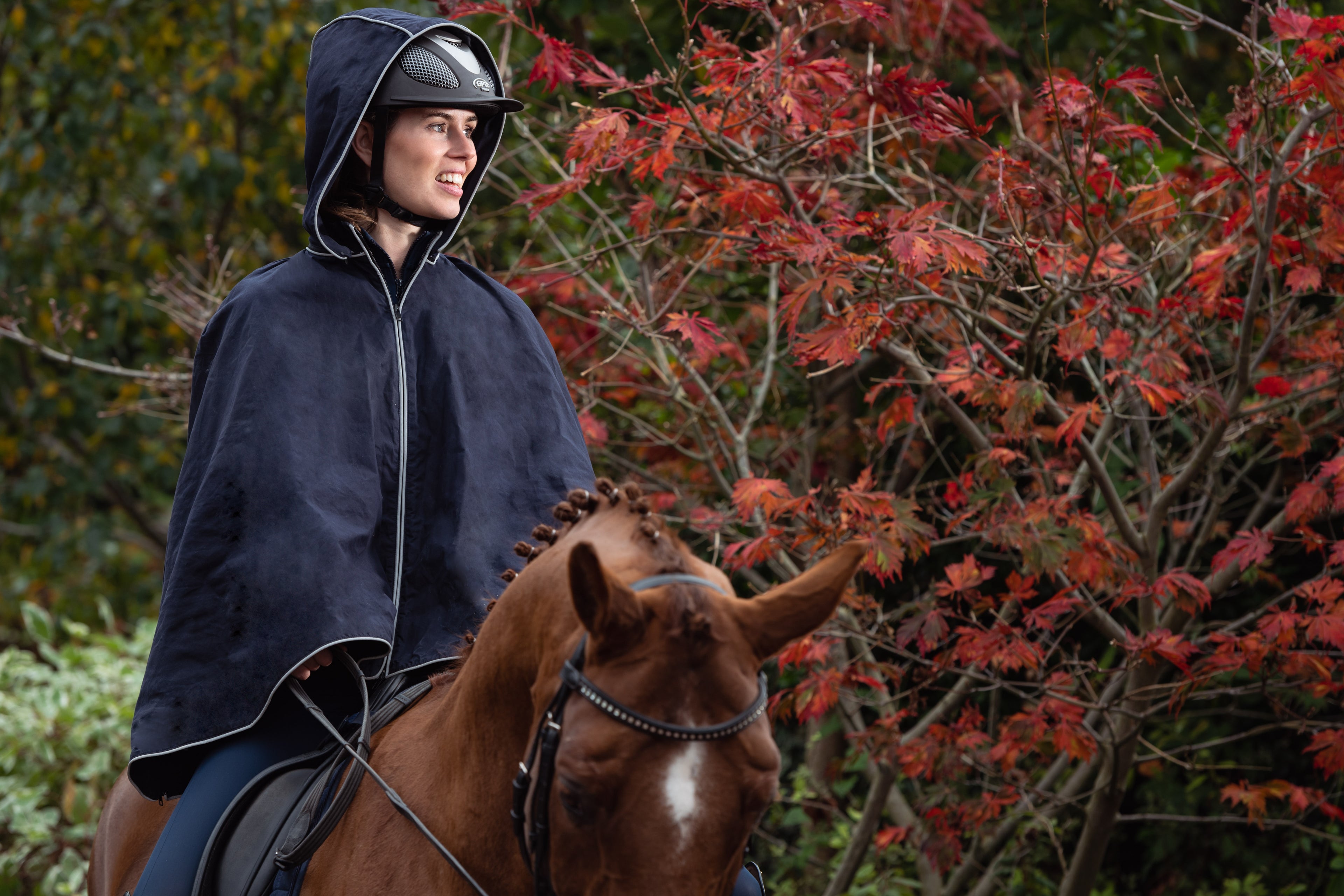 Elisabeth wears the Nini Bos Elisabeth Poncho and Anne riding Leggings on horse